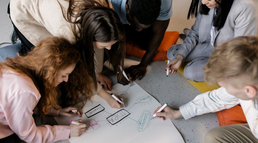 Grupo de jovenes esbozando una idea de negocio sobre papel